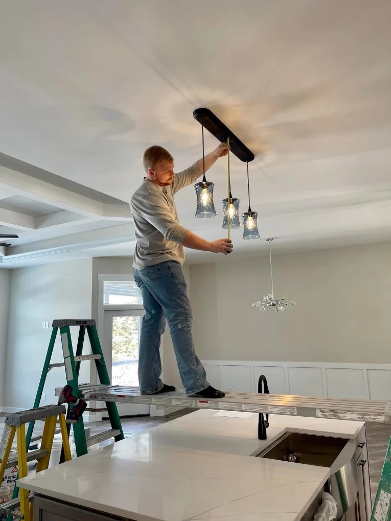 Pendant lights being installed over a kitchen island