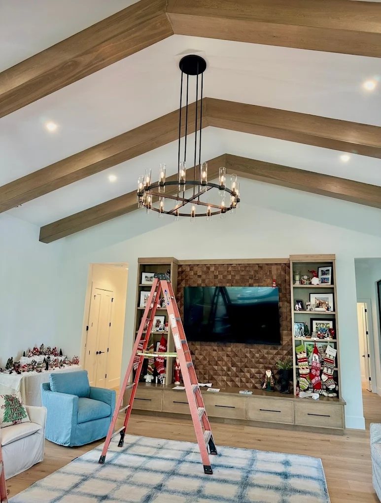Chandelier hung on a vaulted beam ceiling by Carter Electric